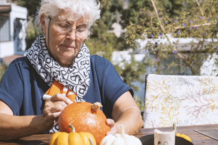 Grandmother Painting a Pumpkin